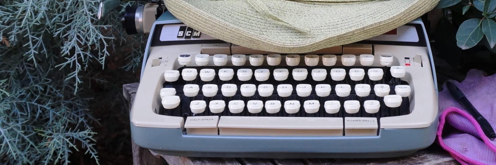 garden writing typewriter in evergreens
