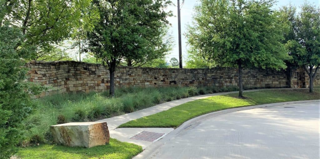 rustic wall in a family neighborhood planted with leafy trees