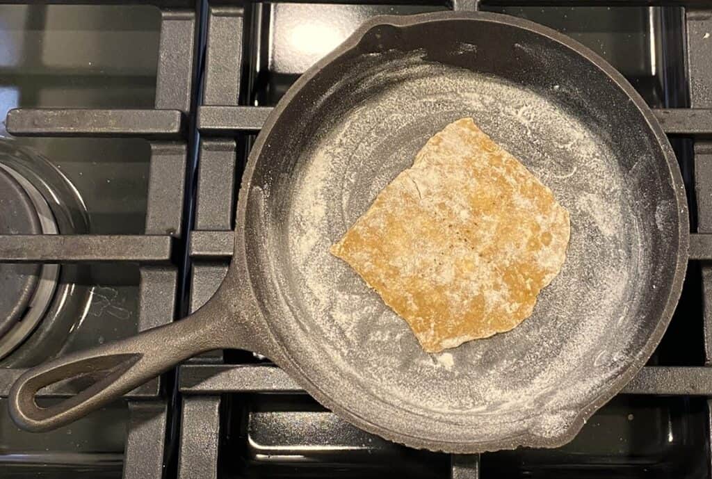Unleavened bread cooking in an iron skillet